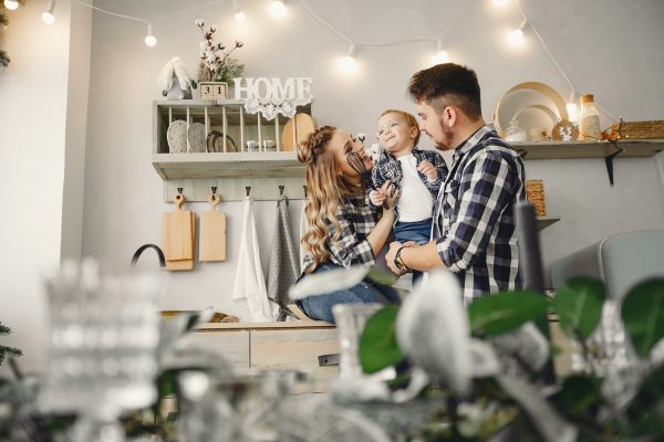 Family on the kitchen. Blonde in a blue shirt. Pregnant woman with her husband and little son